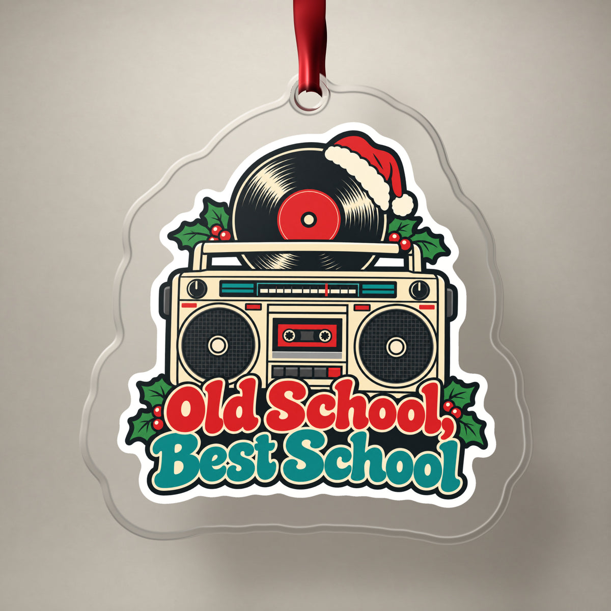 Old School, Best School Boombox clear acrylic Christmas ornament on a plain studio backdrop with its red ribbon