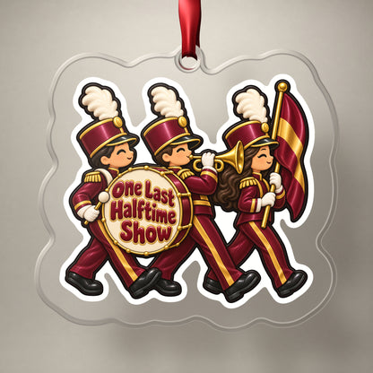 One Last Halftime Show Marching Band clear acrylic Christmas ornament on a plain studio backdrop with its red ribbon