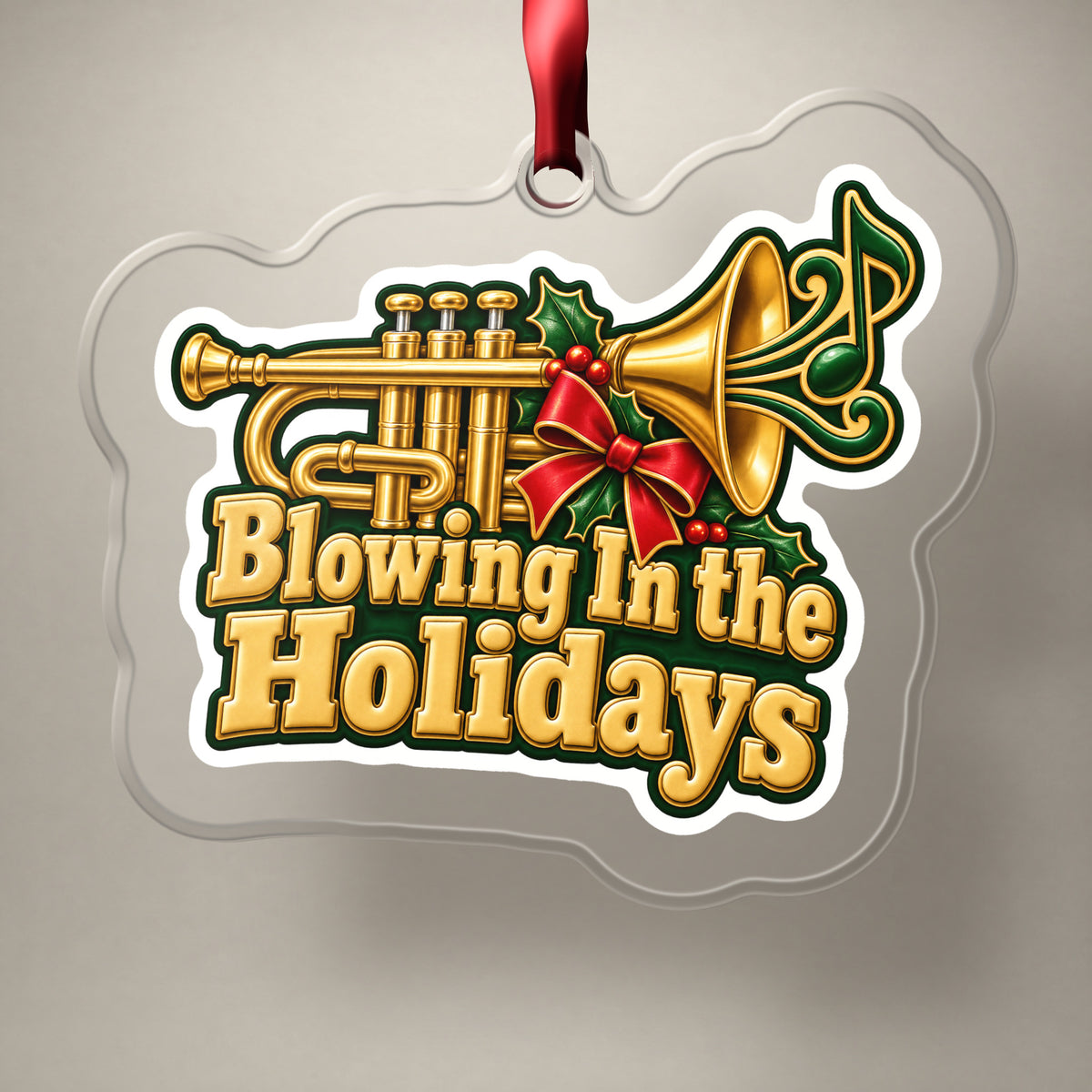 Blowing In the Holidays Trumpet clear acrylic Christmas ornament on a plain studio backdrop with its red ribbon