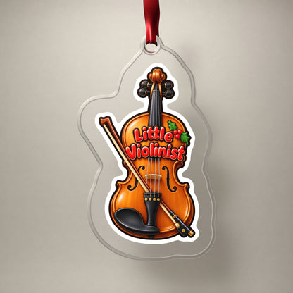 Little Violinist clear acrylic Christmas ornament on a plain studio backdrop with its red ribbon