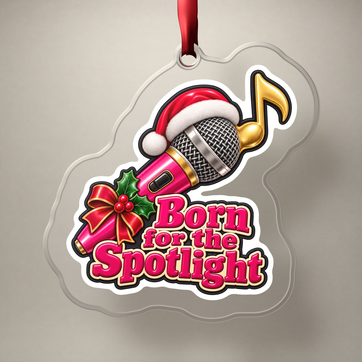 Born for the Spotlight Karaoke Mic clear acrylic Christmas ornament on a plain studio backdrop with its red ribbon