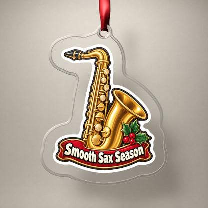 Smooth Sax Season Saxophone clear acrylic Christmas ornament on a plain studio backdrop with its red ribbon