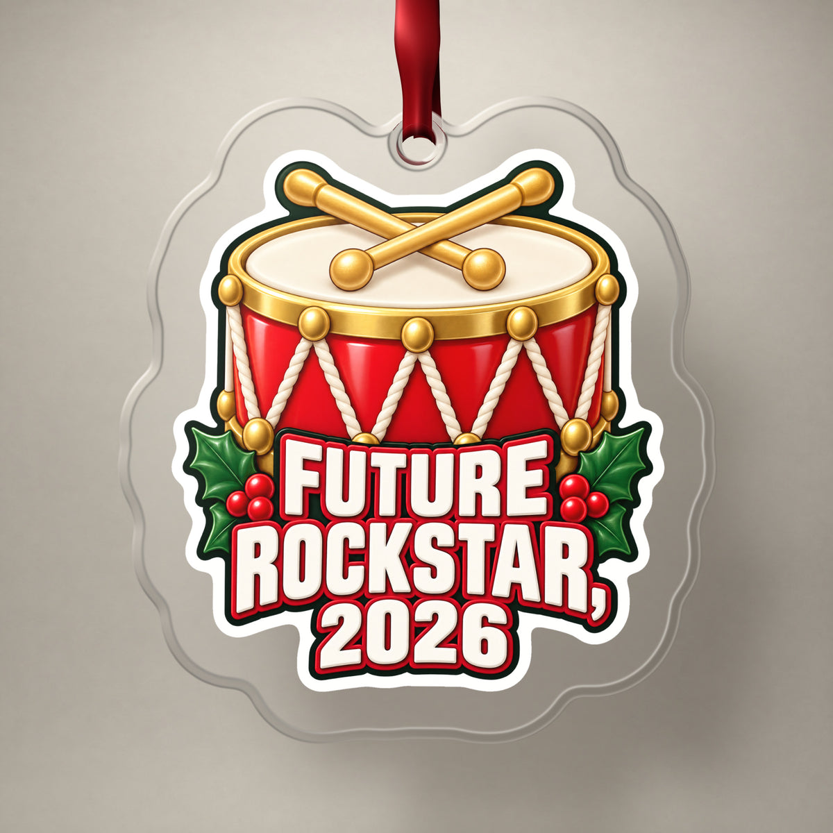 Future Rockstar 2026 Toy Drum clear acrylic Christmas ornament on a plain studio backdrop with its red ribbon