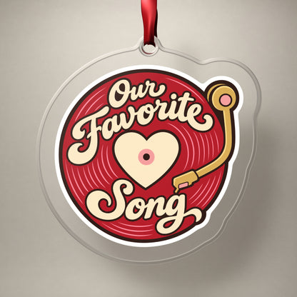 Our Favorite Song Vinyl Record clear acrylic Christmas ornament on a plain studio backdrop with its red ribbon
