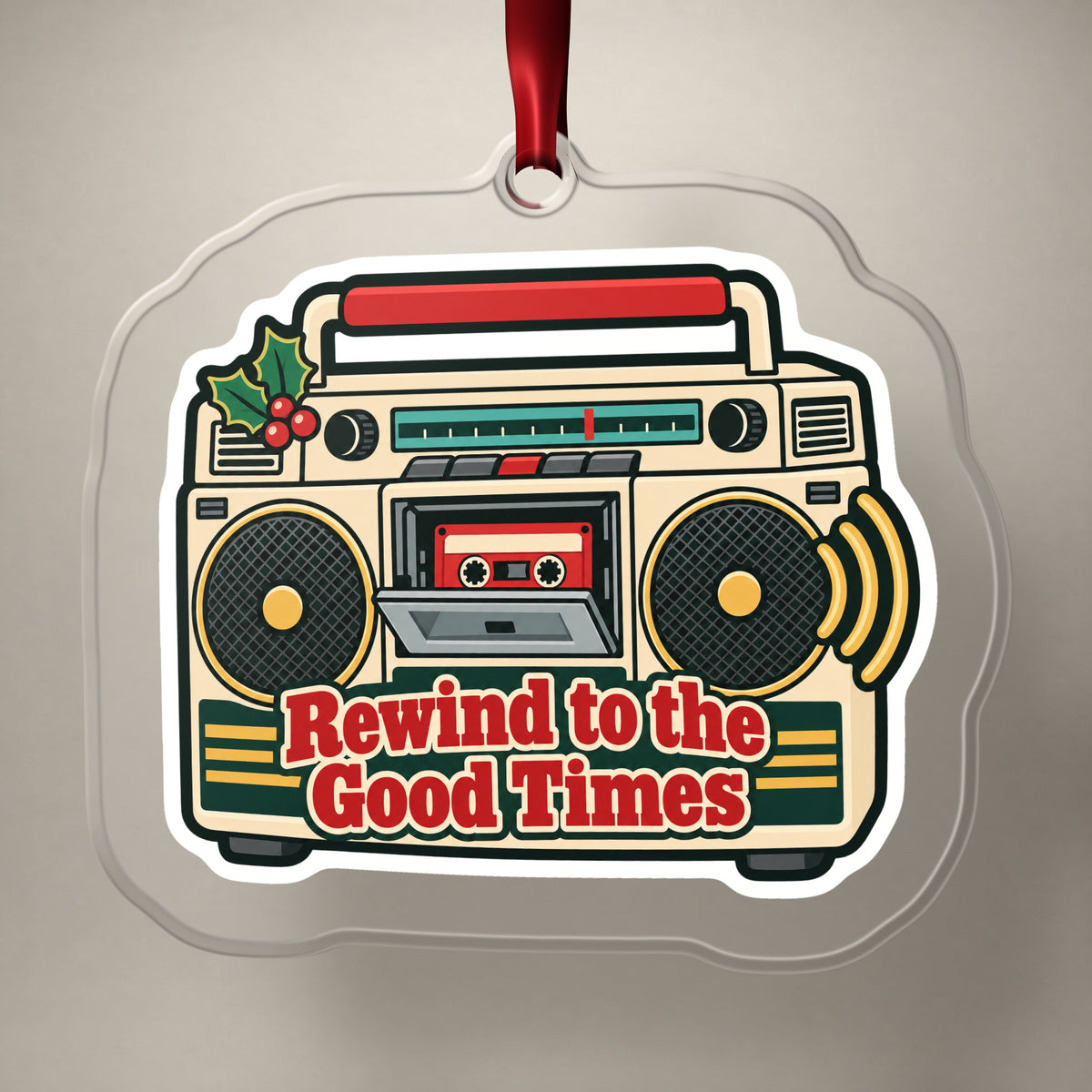 Rewind to the Good Times Boombox clear acrylic Christmas ornament on a plain studio backdrop with its red ribbon