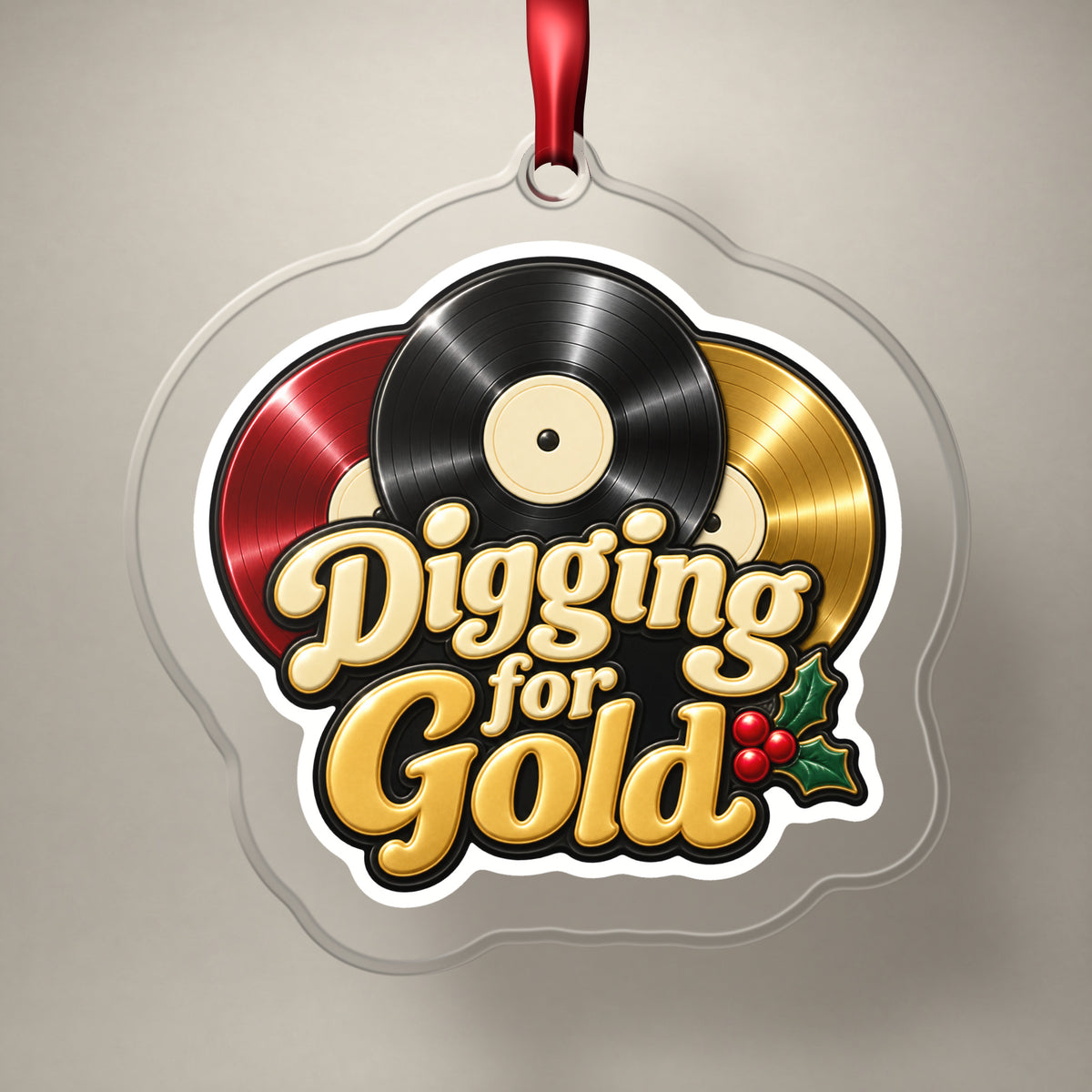 Digging for Gold Vinyl Records clear acrylic Christmas ornament on a plain studio backdrop with its red ribbon