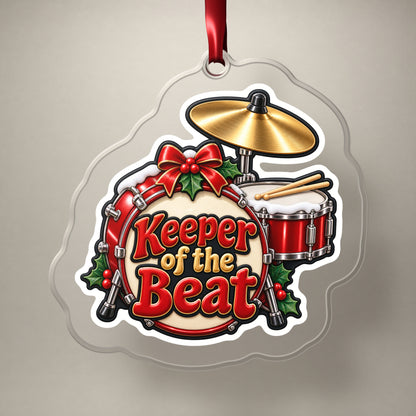 Keeper of the Beat Drum Kit clear acrylic Christmas ornament on a plain studio backdrop with its red ribbon