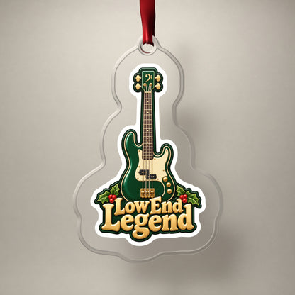 Low End Legend Bass Guitar clear acrylic Christmas ornament on a plain studio backdrop with its red ribbon
