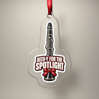 Reed-y for the Spotlight Clarinet clear acrylic Christmas ornament on a plain studio backdrop with its red ribbon