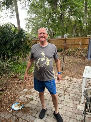 Susie F.'s photo: a smiling man on a patio wearing the grey Lincoln Guitar tee.