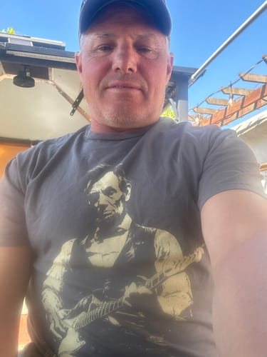 Douglas E. taking a selfie outdoors in the grey Lincoln Guitar tee