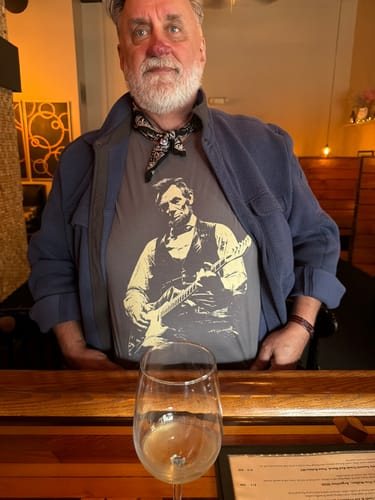 Martin V. in a restaurant wearing the grey Lincoln Guitar tee under an open jacket